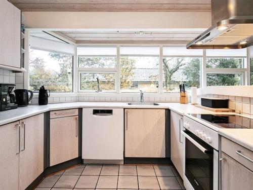 a kitchen with a sink and a stove top oven at 8 person holiday home in Bl vand in Blåvand
