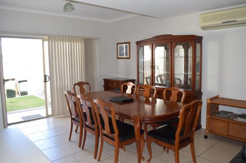 a dining room with a wooden table and chairs at Christies Seahorse Holiday Townhouses in Port Noarlunga