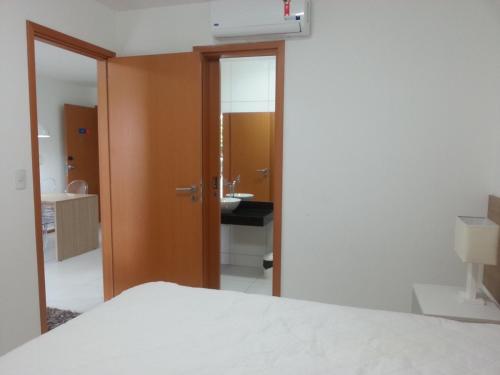 a bedroom with a bed and a bathroom with a sink at Iloa Residence1 in Barra de São Miguel