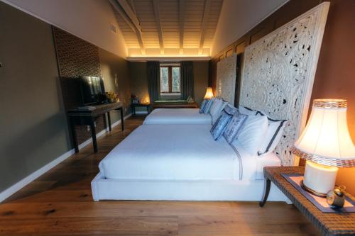 a bedroom with two beds and a table with a lamp at Bann at Oak Knoll Napa in Napa