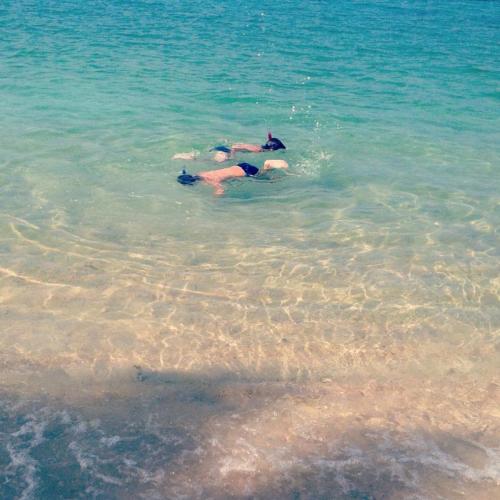 two people swimming in the water in the ocean at Jasmine & Tea House in Mae Nam
