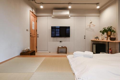 a bedroom with a bed and a tv on the wall at Humanlive in Tainan
