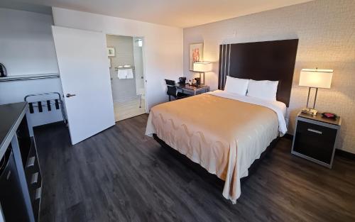 a hotel room with a large bed and a kitchen at Quality Inn Burbank Airport in Burbank
