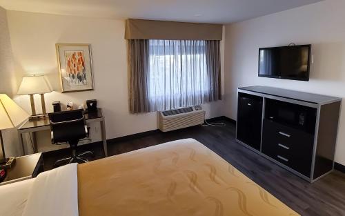 a hotel room with a bed and a flat screen tv at Quality Inn Burbank Airport in Burbank