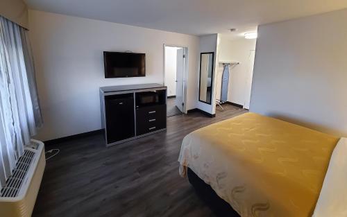 a hotel room with a bed and a flat screen tv at Quality Inn Burbank Airport in Burbank