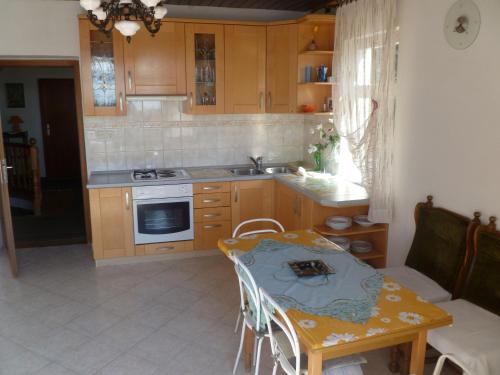 een keuken met een tafel en een eetkamer bij Rooms Jakirusa in Brela