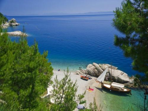 een strand met twee boten op het zand en het water bij Rooms Jakirusa in Brela