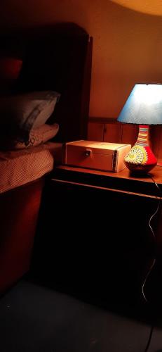 a bed with a nightstand with a lamp and a nightstand at The cottage and cheese in Manāli