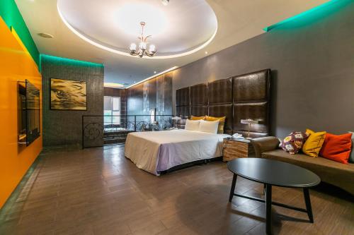 a hotel room with a bed and a couch at Vogue Boutique Motel in Yangmei
