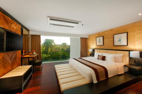 Postel nebo postele na pokoji v ubytování de Vins Sky Hotel Seminyak
