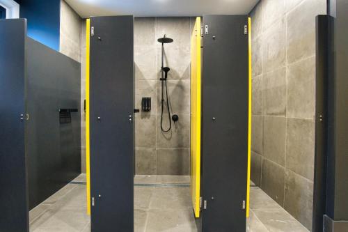 a bathroom with a shower with yellow dividers in it at Dreamy Stays Accommodation - Private Rooms with Shared Bathrooms in Adelaide