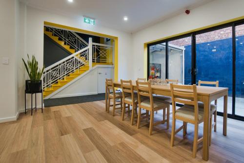 a dining room with a table and chairs and a staircase at Dreamy Stays Accommodation - Private Rooms with Shared Bathrooms in Adelaide
