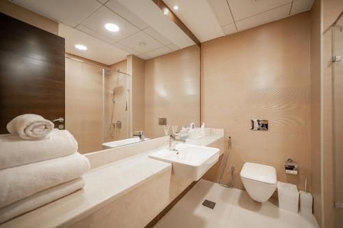 La salle de bains est pourvue d'un lavabo, de toilettes et d'un miroir. dans l'établissement Luton Vacation Homes - Sparkle Towers, Dubai Marina 20AB 7, à Dubaï
