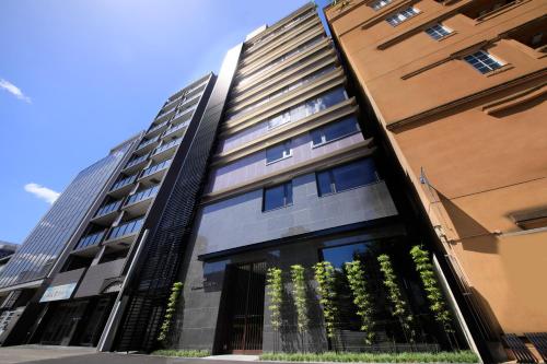 a tall building with plants in front of it at The Hedistar Hotel Kyoto Nijo Comic & Books in Kyoto