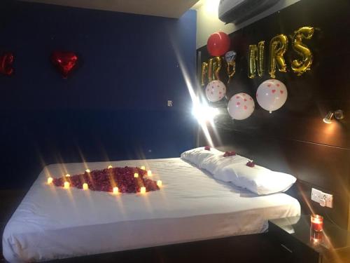 a room with a cake on a bed with balloons at Hira Guest House in Karachi