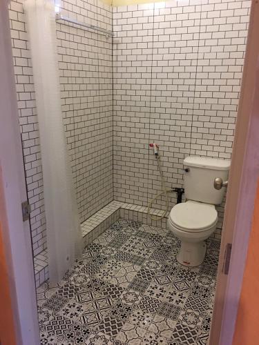 a bathroom with a toilet and a tiled floor at บ้านศรีสมบูรณ์ เชียงคาน in Chiang Khan