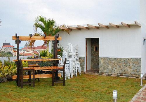 a patio with chairs and a table and a building at Sky Garden Hotel by RedDoorz in Roxas City
