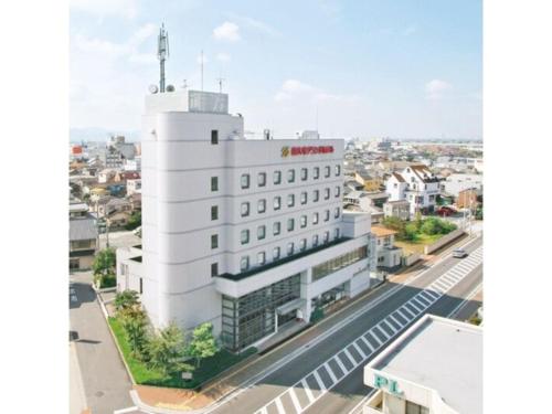Un bâtiment blanc avec un panneau rouge en haut dans l'établissement SAIDAIJI GRAND HOTEL - Vacation STAY 67891v, à Setouchi