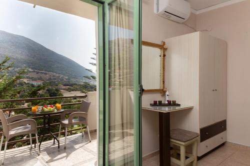 a room with a balcony with a table and chairs at Minas Apartments in Divarata