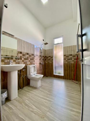 a bathroom with a toilet and a sink at Mountain White Villa by Sunrise in Kandy