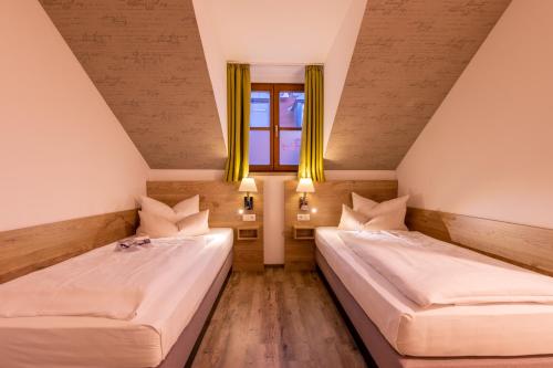 two beds in a room with a window at Zur Post Kümmersbruck Hotel & Tiny Houses in Kümmersbruck