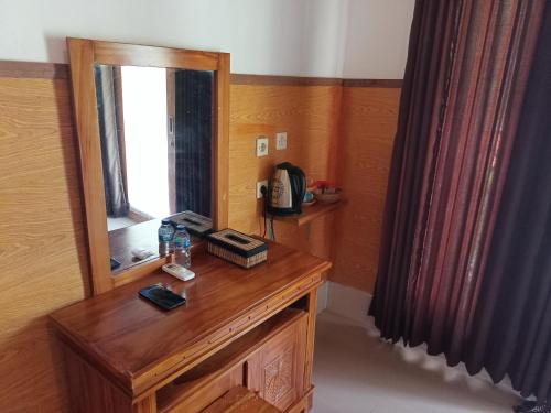a room with a wooden table with a mirror at Grealeen Cottages in Nusa Penida