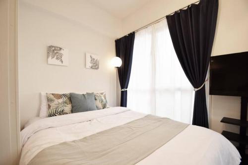 ein Schlafzimmer mit einem weißen Bett und einem Fenster in der Unterkunft enジョイマールひろ 401 in Tomari
