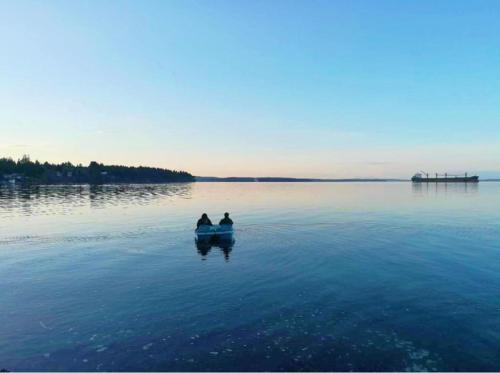 two people are sitting in a boat in the water at Walkon Waterfront Castle Cove Inn in Chemainus