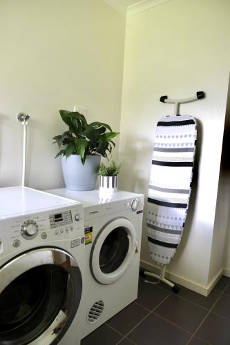 a laundry room with a washing machine and a plant at Belford House in Myrtleford