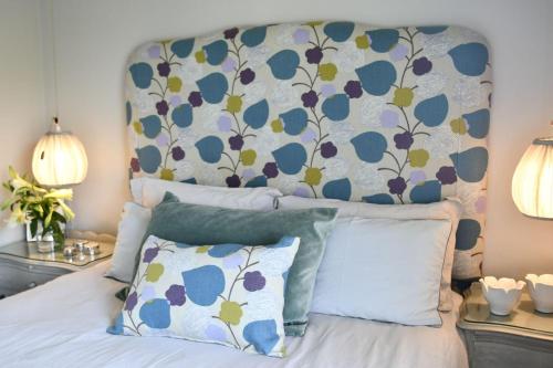 a bedroom with a bed with a floral headboard at The Great Gatsby Houghton in Johannesburg