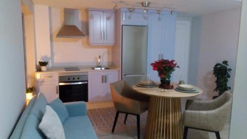 uma cozinha com uma mesa e um sofá azul em Estudio jacuzzi Luz de Jerez em Jerez de la Frontera