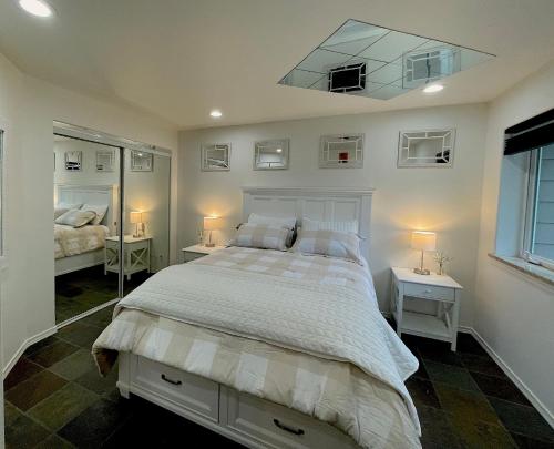 een slaapkamer met een groot bed met 2 tafels en een spiegel bij Precision Lodge - Three one bedroom units and two rooms in a shared house - DISCOUNT ON TOURS! in Mendenhaven