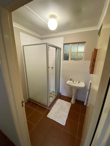 a bathroom with a shower and a sink at Under The Oak in Underberg