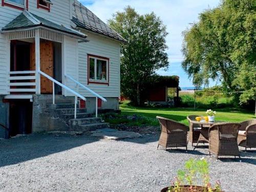 a patio with a table and chairs in front of a house at 9 person holiday home in Fj rtoft in Fjørtoft