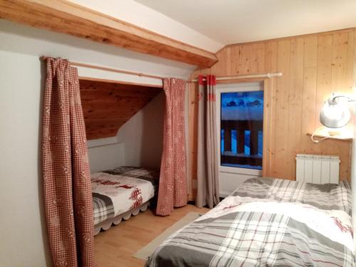 une chambre avec un lit et une fenêtre dans l'établissement Au grenier du lac, à Gérardmer