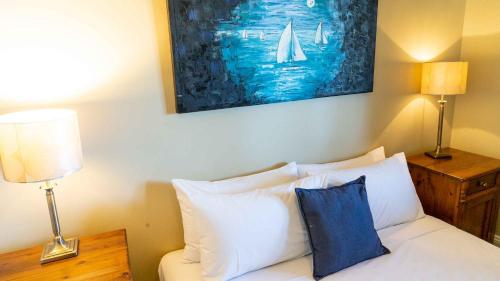 a bedroom with a bed with two lamps and a painting at Anchorage Seafront Hotel in Victor Harbor