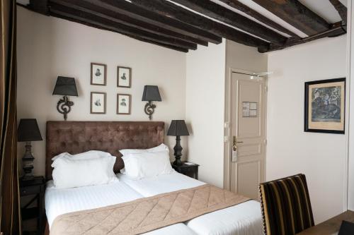 a bedroom with a large bed with white pillows at Hotel Saint-Louis Marais in Paris