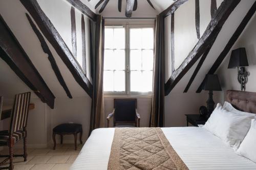 a bedroom with a bed and a window at Hotel Saint-Louis Marais in Paris