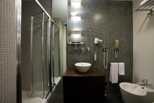 a bathroom with a sink and a toilet and a shower at Hotel Ancora in Verbania
