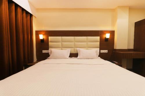 a bedroom with a large white bed with two pillows at FabHotel Blueark in Lucknow