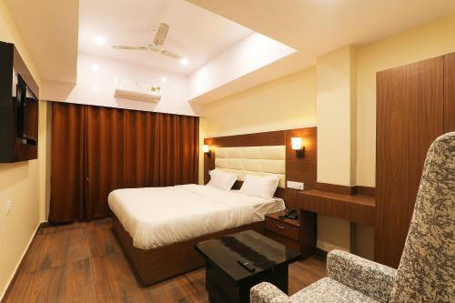a hotel room with a bed and a chair at FabHotel Blueark in Lucknow