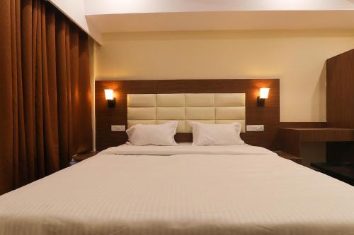 a bedroom with a large white bed with two pillows at FabHotel Blueark in Lucknow