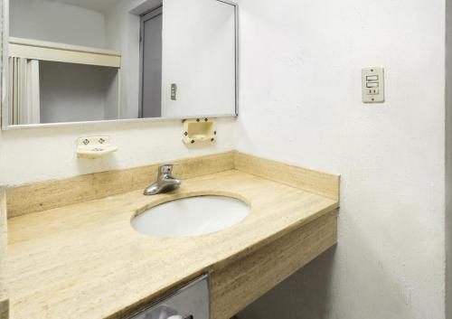 a bathroom with a sink and a mirror at Hotel San Jorge in Saltillo