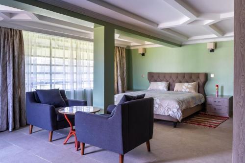 Alphas Homestay في نيفاشا: غرفة نوم بسرير وكرسيين وطاولة