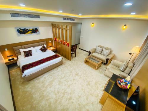 een slaapkamer met een bed, een bank en een stoel bij S R Continental in Gulbarga