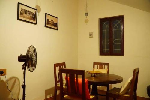 a dining room with a table and chairs and a fan at TANJORE INN in Thanjāvūr