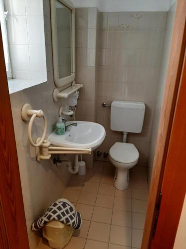 a bathroom with a toilet and a sink and a mirror at B&B Hotel Dolomiti in Bolzano