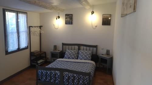 ein Schlafzimmer mit einem Bett, zwei Tischen und einem Fenster in der Unterkunft L'ilot de Carpentras in Carpentras