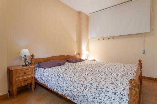 um quarto com uma cama e um candeeiro numa mesa de cabeceira em Apartment with sea view em Almuñécar