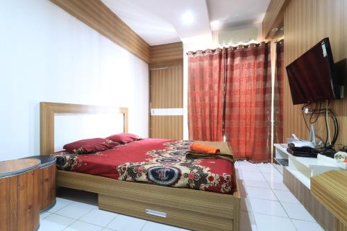 a bedroom with a bed and a flat screen tv at Apartment Paragon Village by Tere Room in Tangerang
